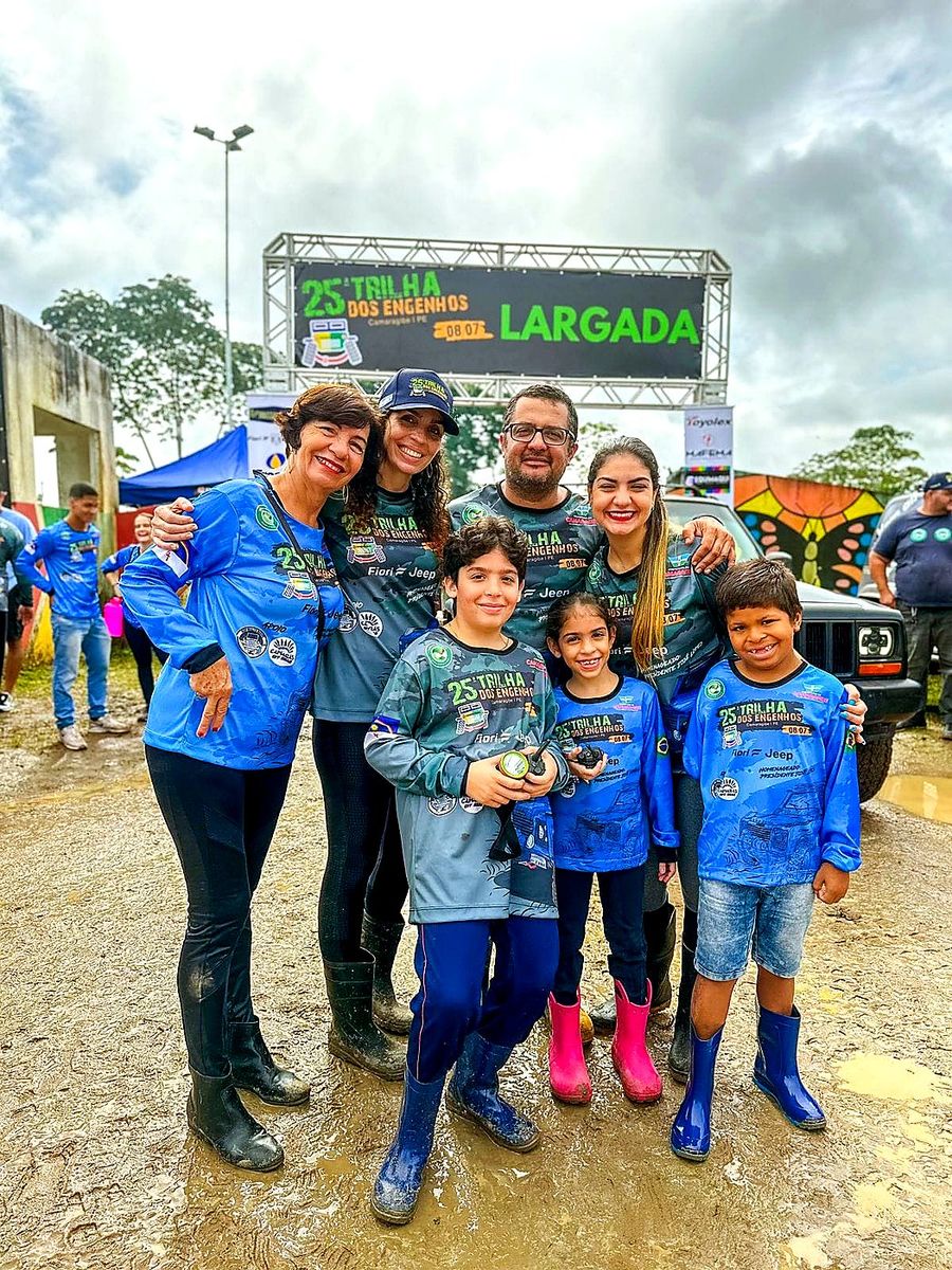 Família com crianças usando walkie-talkies em frente ao portal LARGADA da 25ª edição