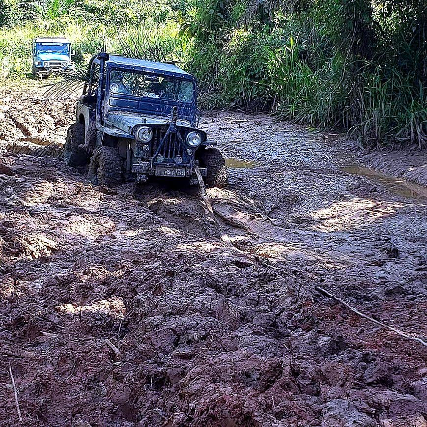 Jeep escalando trincheira de barro vermelho