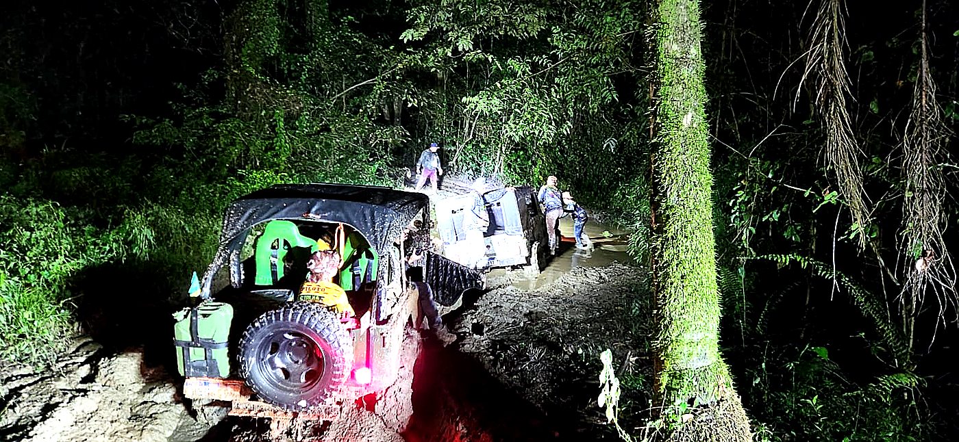 Jeeps atravessando igarapé na mata atlântica à noite