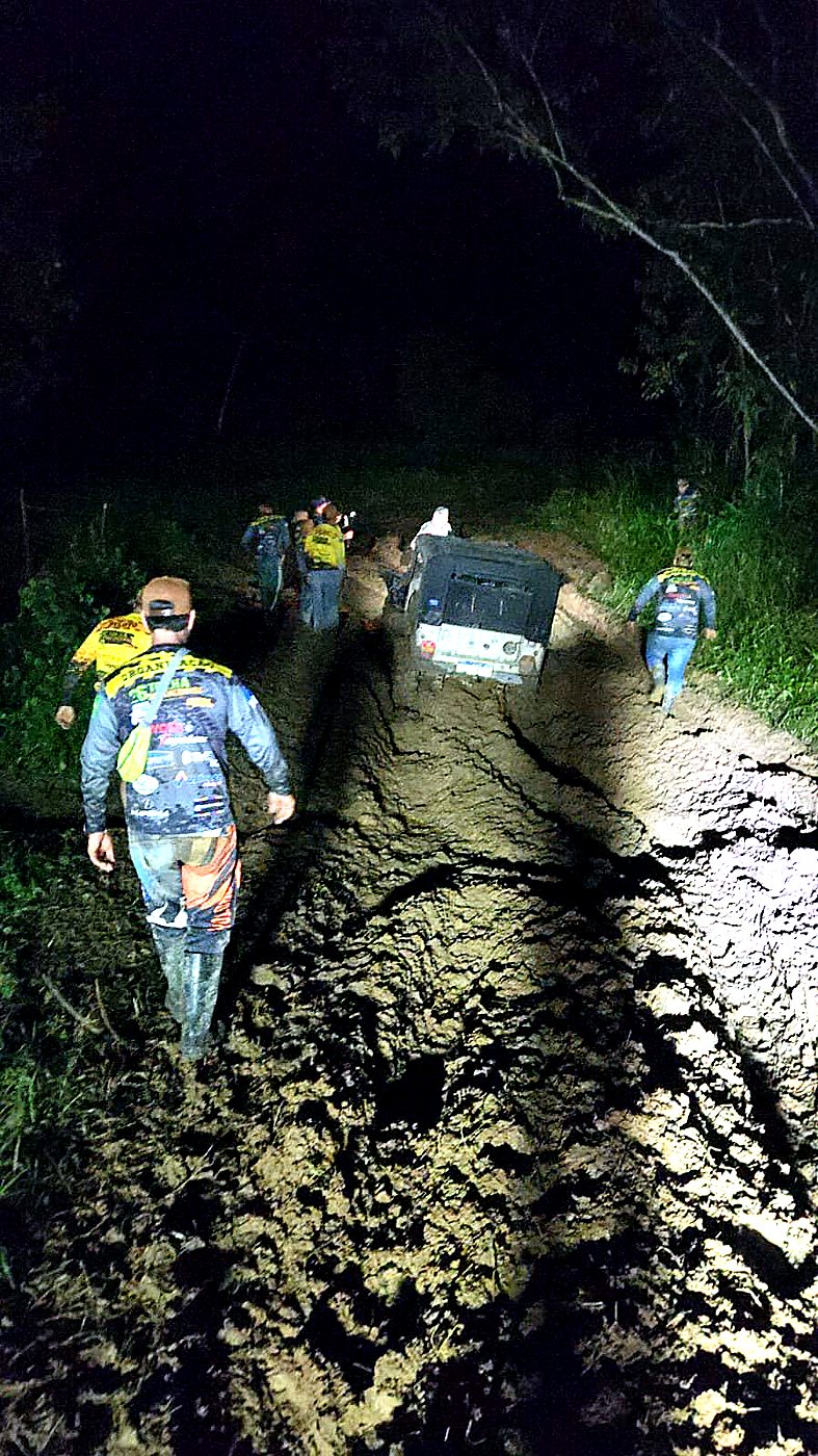 Equipe Anarquia caminhando na vala lamacenta à noite